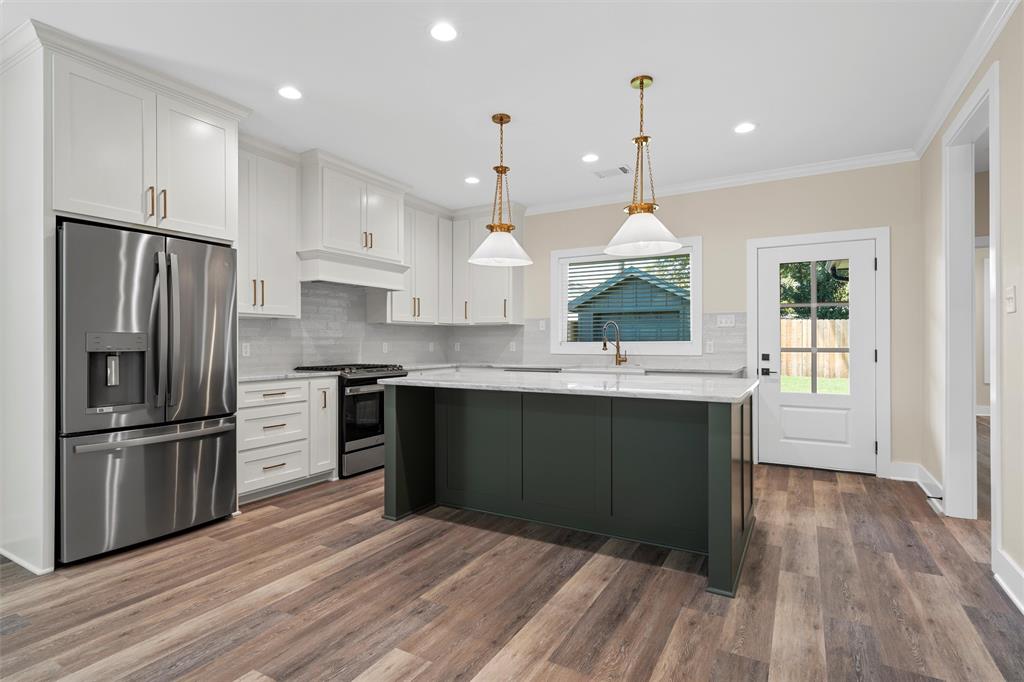 2923 Reuter Avenue Waco, TX 76708 - Photo 8 of 34 a kitchen with stainless steel appliances granite countertop a refrigerator a sink dishwasher a stove and white cabinets with wooden floor