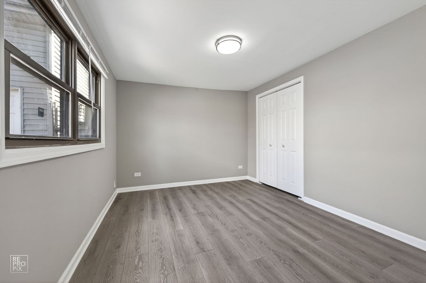 4680 West 83rd Street Chicago, IL 60652 - Photo 14 of 22 a view of an empty room with wooden floor and a window