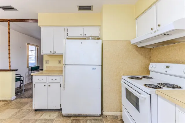 a view of a kitchen with a sink and dishwasher with wooden floor