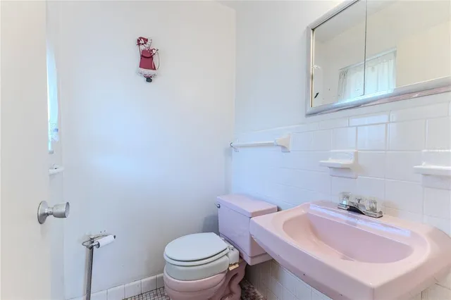a bathroom with a sink a toilet and mirror