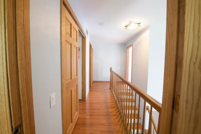 a view of a hallway with wooden floor and stairs