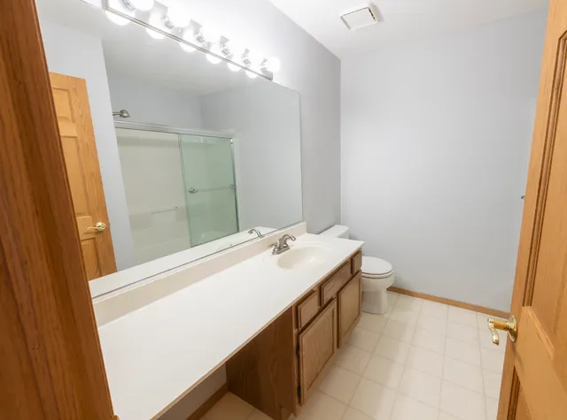 a bathroom with a sink a toilet and a mirror