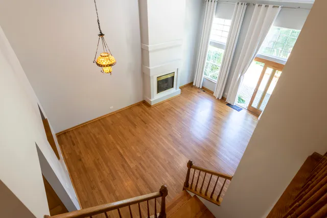 a view of an empty room with wooden floor and windows