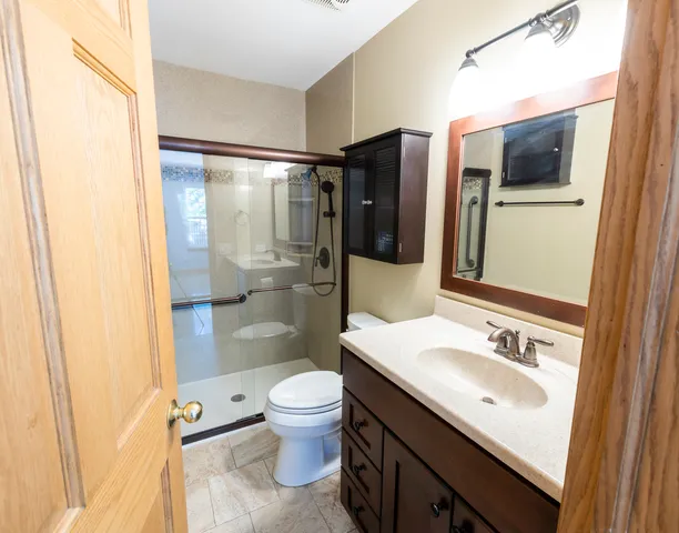 a bathroom with a granite countertop sink toilet and shower