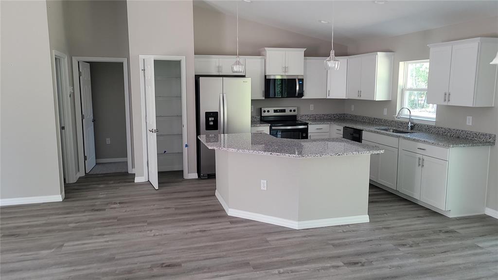 19231 Southwest 97th Street Dunnellon, FL 34432 - Photo 2 of 31 a kitchen with stainless steel appliances a sink a stove a refrigerator and cabinets