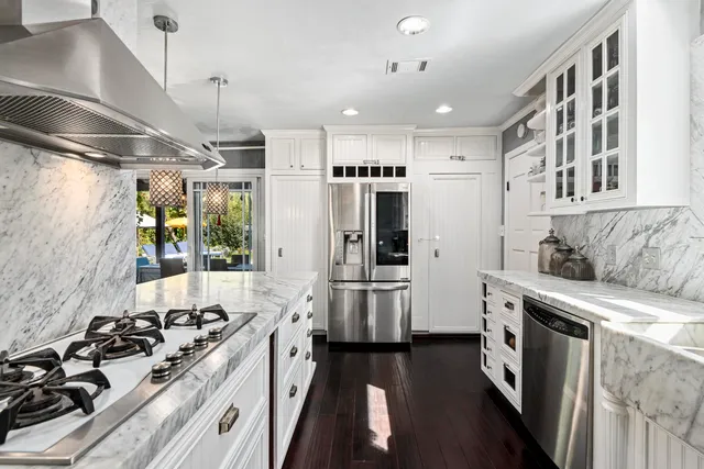 a kitchen with stainless steel appliances a stove a sink and a refrigerator