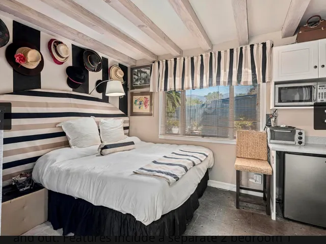 a bedroom with a bed and a large window with the balcony view
