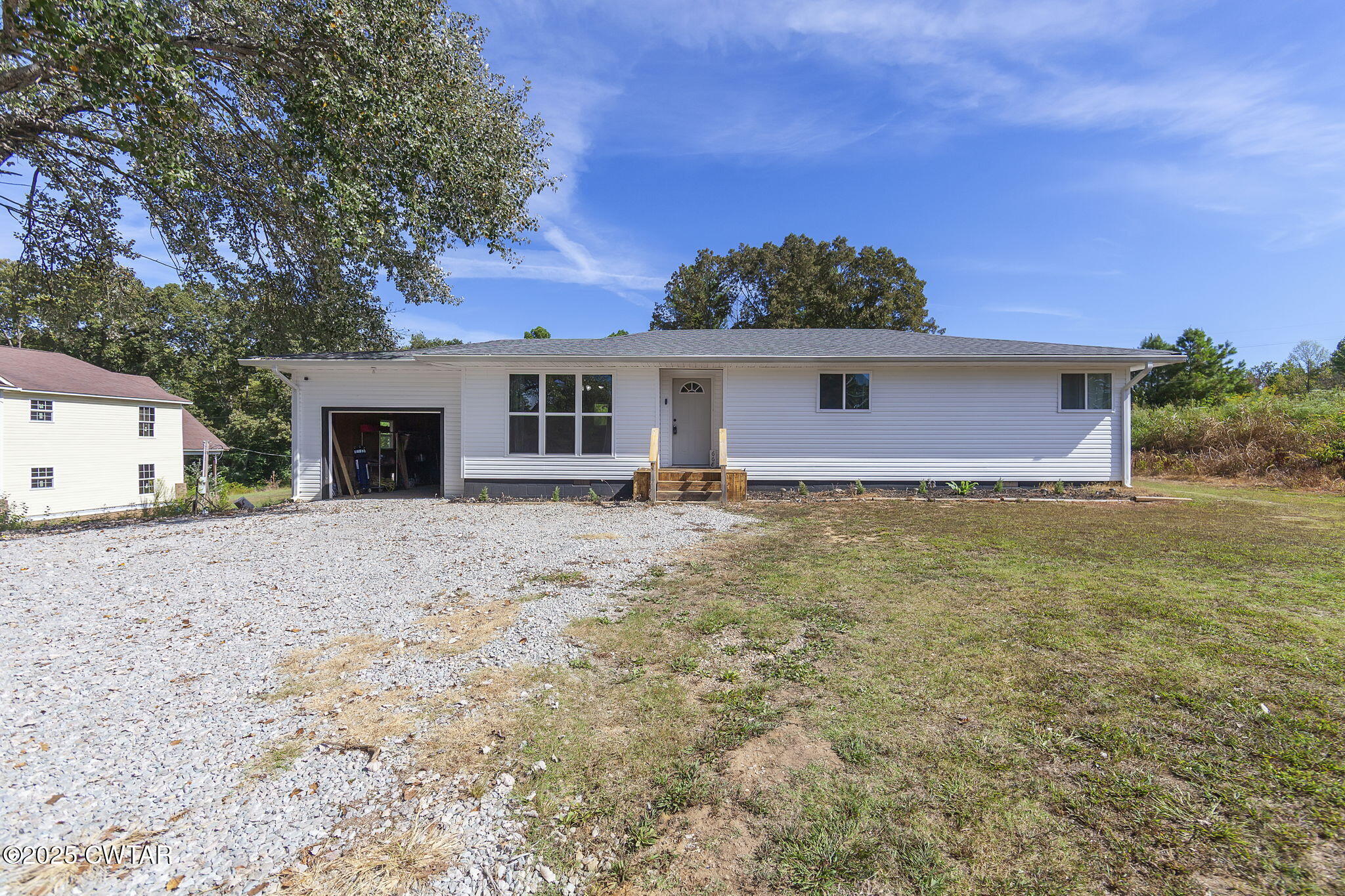 a front view of house with yard and trees around