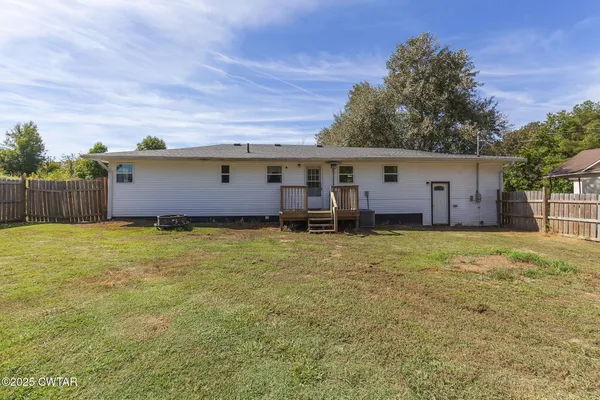 a view of a house with backyard and tree