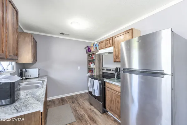 a kitchen with stainless steel appliances granite countertop a refrigerator a stove and a sink
