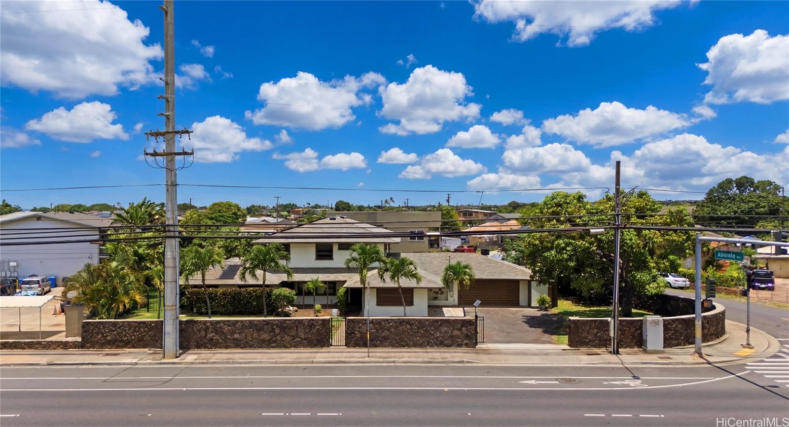91-779 Fort Weaver Road Ewa Beach, HI 96706 - Photo 23 of 25 Front exterior view showing the perimeter rock wall, gated entry, and corner driveway.