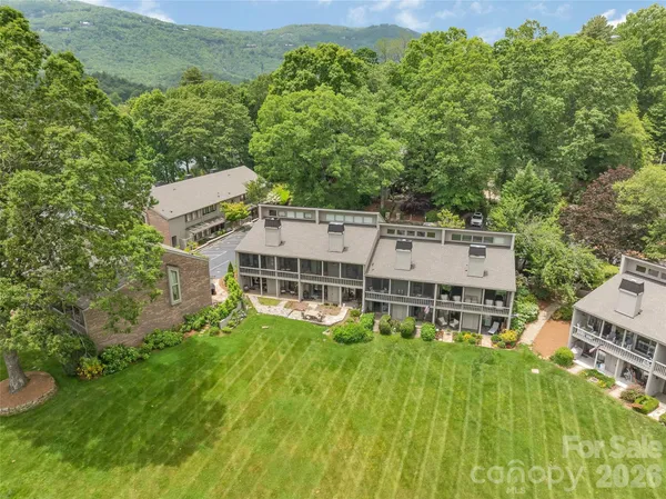an aerial view of residential houses with outdoor space and trees
