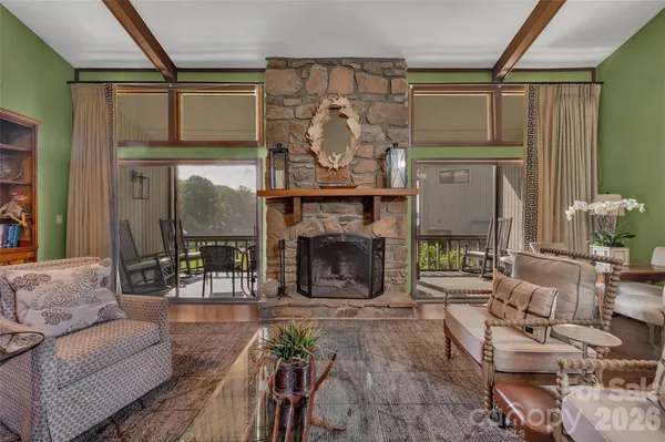 a living room with fireplace furniture and a large window