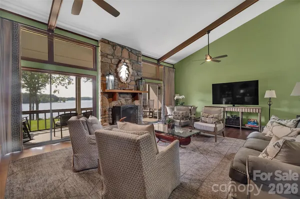 a living room with furniture a fireplace and large windows