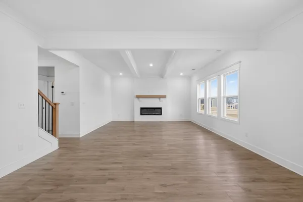 a view of an empty room with a window and fireplace