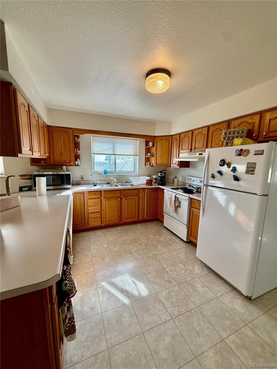 6216 Moreland Road Boone, CO 81025 - Photo 12 of 37 a kitchen with stainless steel appliances granite countertop a stove top oven a sink a dining table and chairs