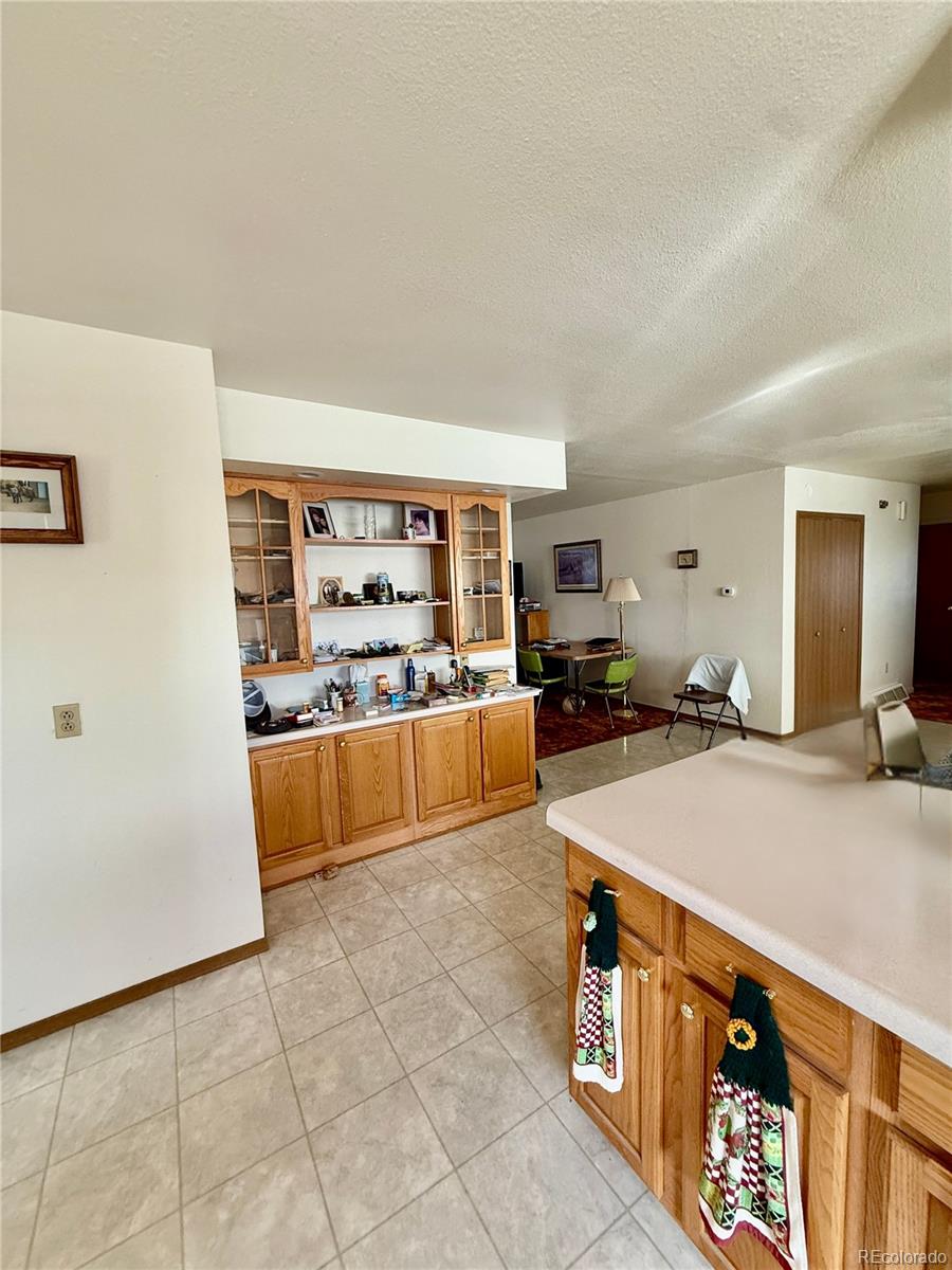 6216 Moreland Road Boone, CO 81025 - Photo 13 of 37 a living room with stainless steel appliances kitchen island granite countertop a sink and cabinets