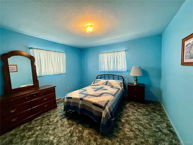 a bedroom with a bed lamp and a dresser