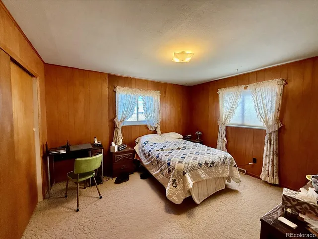 a bedroom with a bed chair and window