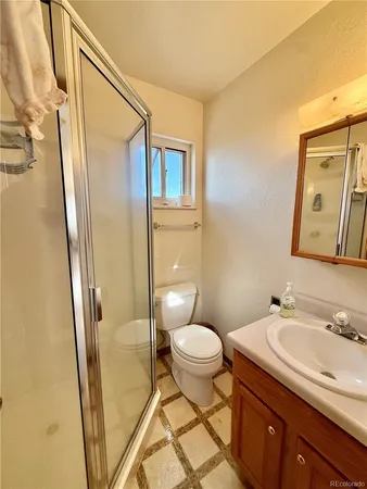 a bathroom with a granite countertop sink toilet and shower