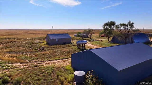 a view of a backyard with table and chairs potted plants
