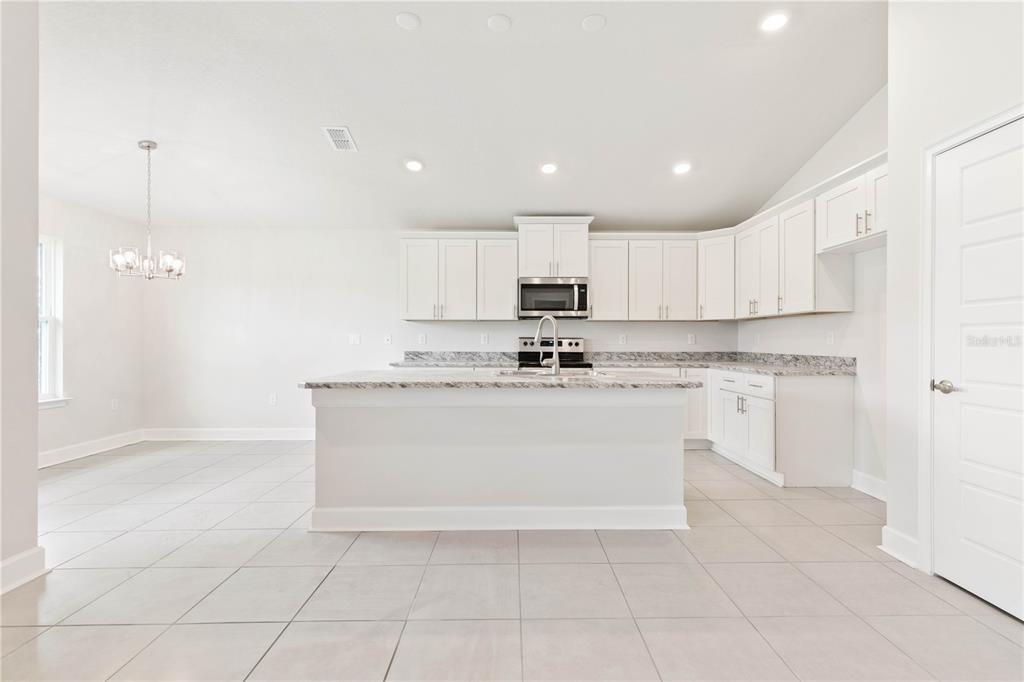 90 Rivertown Road Palm Coast, FL 32137 - Photo 35 of 60 a view of kitchen with granite countertop white cabinets and stainless steel appliances