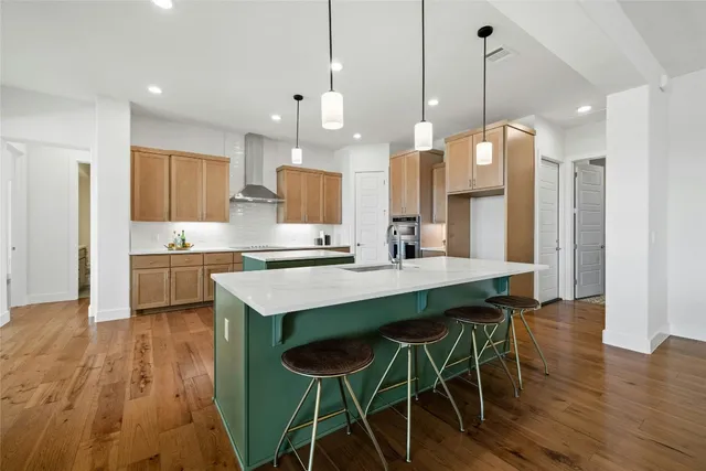 a kitchen with kitchen island a wooden floor and white appliances