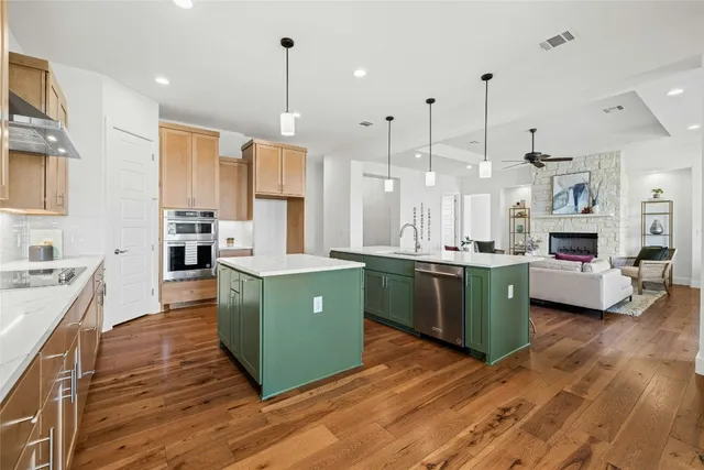 a large kitchen with kitchen island white cabinets and stainless steel appliances