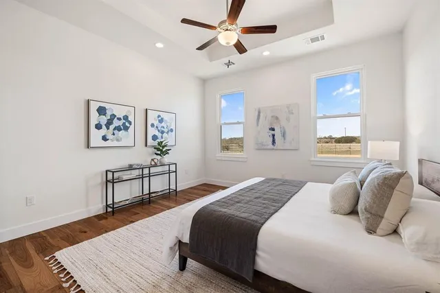 a bedroom with a bed ceiling fan and a window