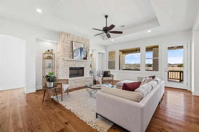 a living room with furniture a flat screen tv and wooden floor