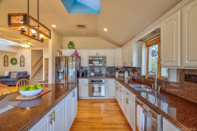 a open kitchen with stainless steel appliances granite countertop a sink and counter space