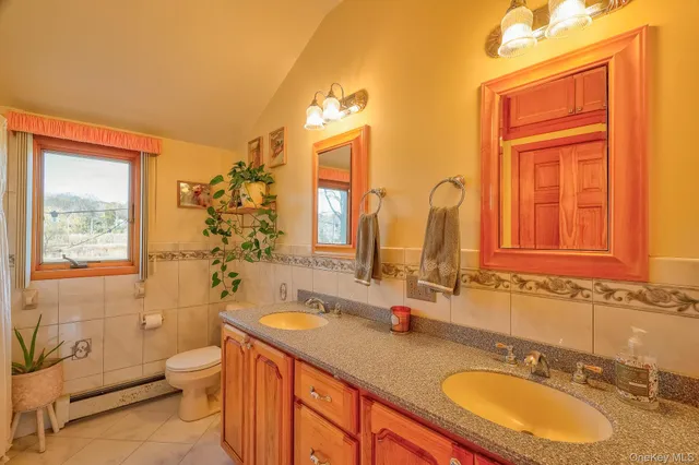 a bathroom with a granite countertop toilet sink and mirror