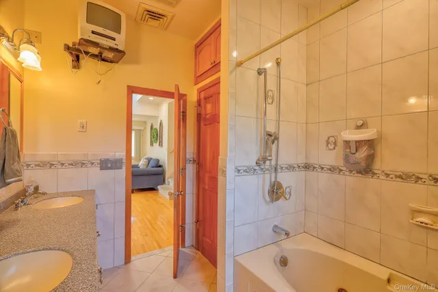 a bathroom with a tub a sink and a shower