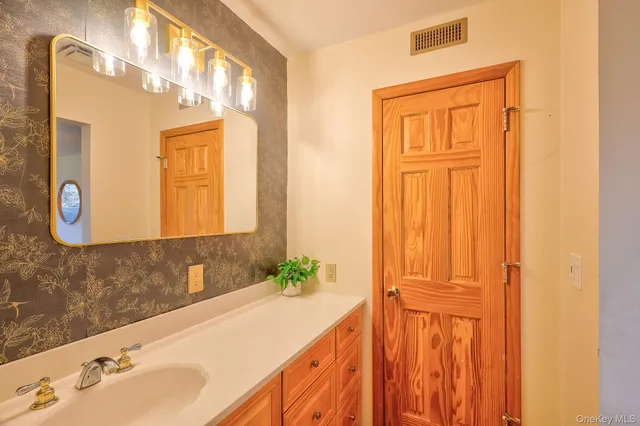 a bathroom with a tub sink and mirror