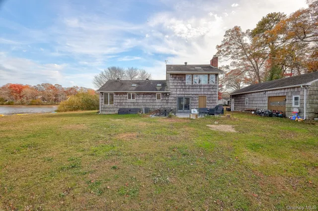 a view of a house with a big yard and large trees