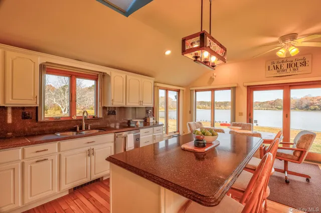 a view of a kitchen and dining room with furniture large windows and wooden floor