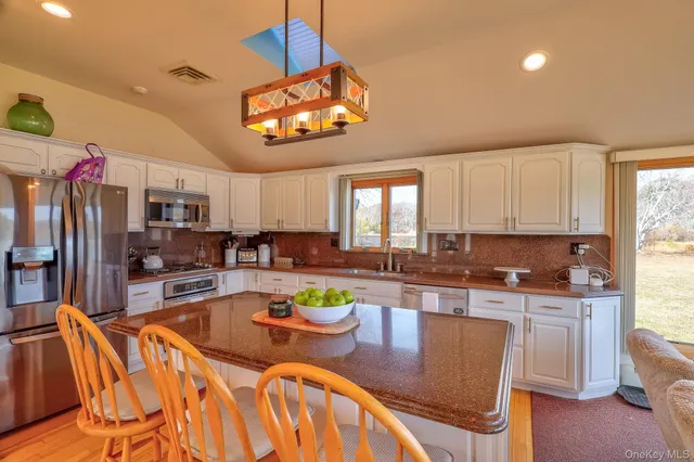 a view of a dining room with furniture a kitchen and chandelier
