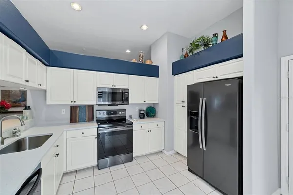 a kitchen with stainless steel appliances a refrigerator sink and microwave