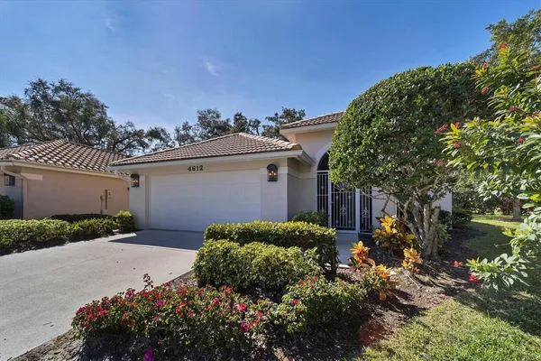 a view of a house with a yard and potted plants