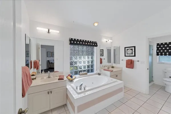 a spacious bathroom with a tub sink and mirror