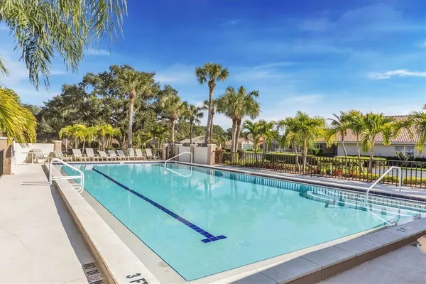 a view of a swimming pool with a lawn chairs under an umbrella