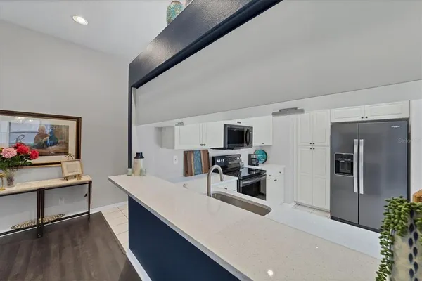 a kitchen with stainless steel appliances kitchen island sink refrigerator and stove