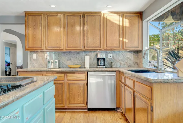 a kitchen with stainless steel appliances granite countertop wooden cabinets a table and chairs
