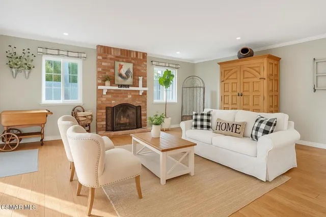 a living room with furniture a fireplace and a floor to ceiling window