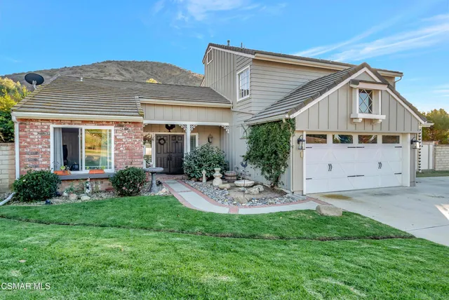a view of a house with a yard and sitting area
