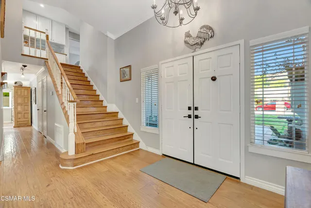 a view of a hallway with entryway wooden floor and front door