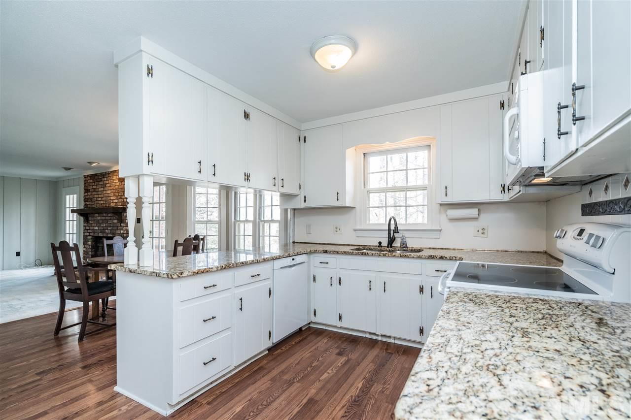 4516 Connell Drive Raleigh, NC 27612 - Photo 11 of 28 a kitchen with granite countertop cabinets stainless steel appliances a sink and a window
