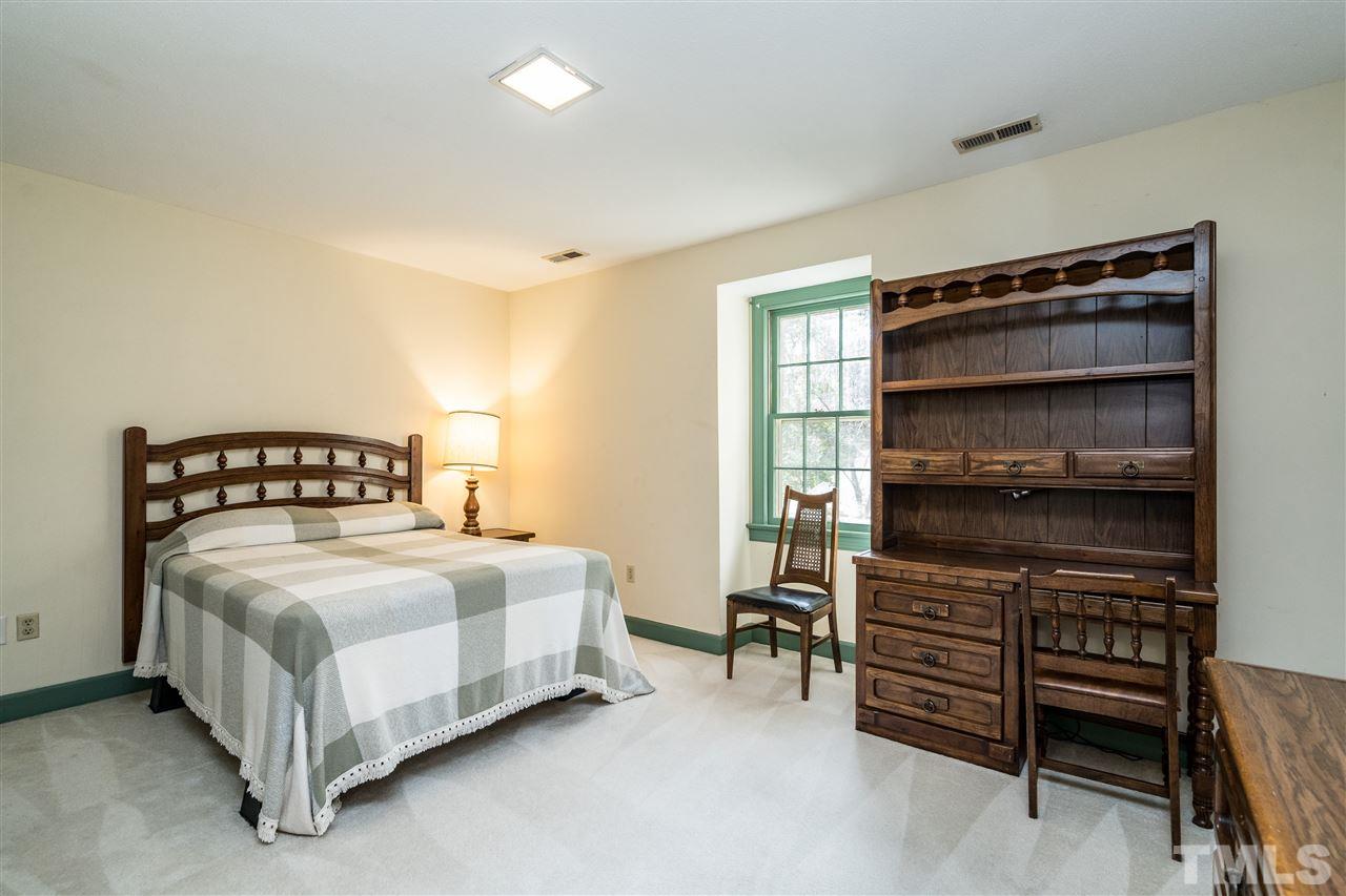 4516 Connell Drive Raleigh, NC 27612 - Photo 19 of 28 a bedroom with a bed and a cabinets