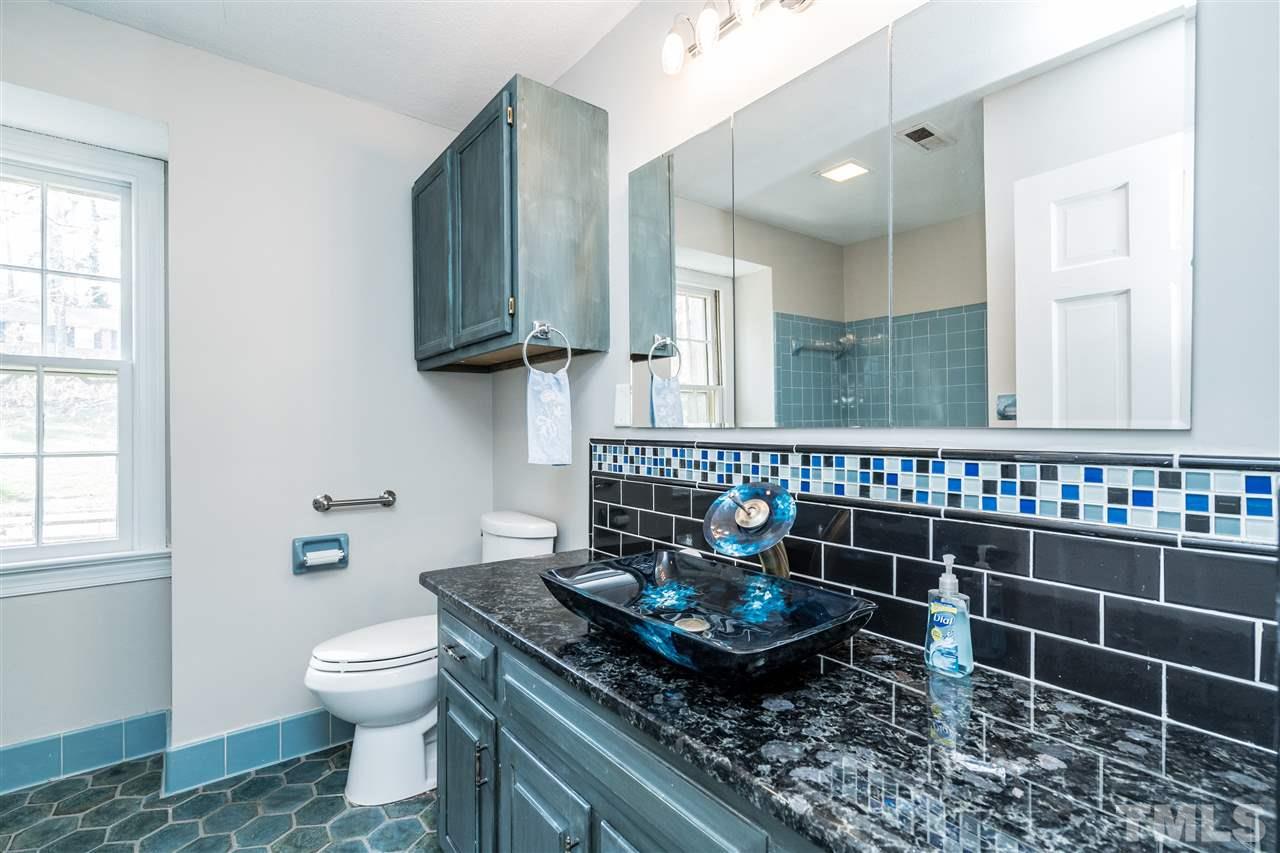 4516 Connell Drive Raleigh, NC 27612 - Photo 21 of 28 a bathroom with a granite countertop sink and a mirror