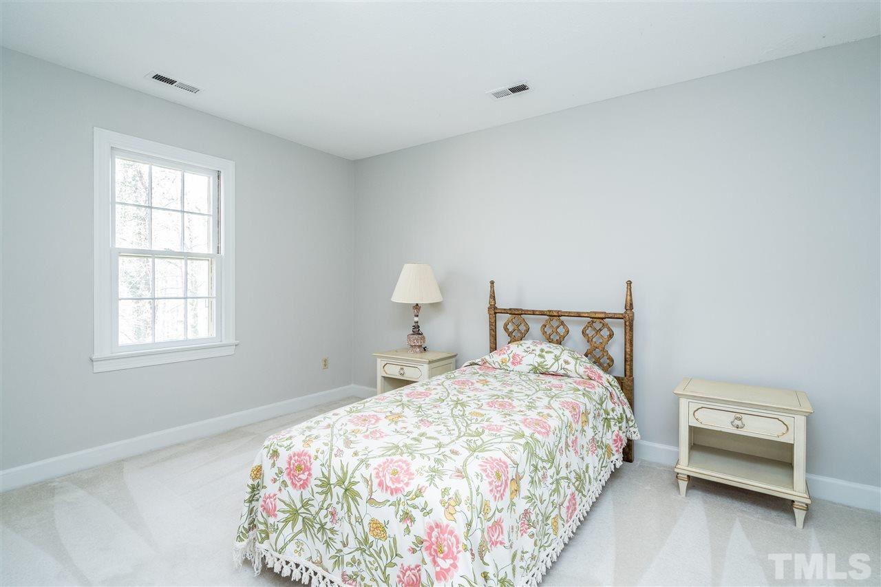 4516 Connell Drive Raleigh, NC 27612 - Photo 22 of 28 a bedroom with a bed and a chair